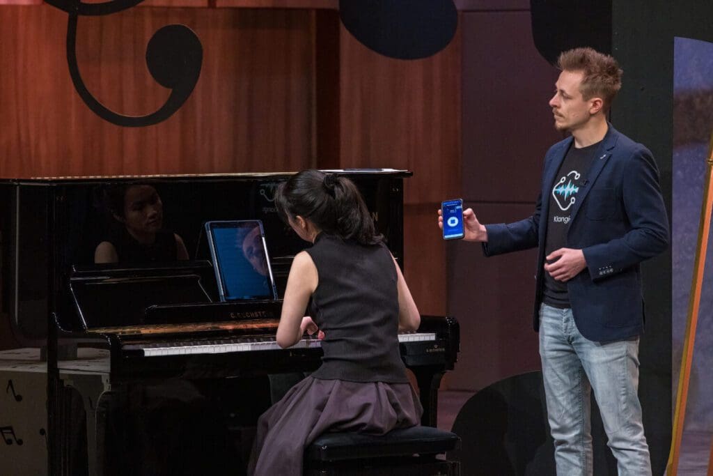 Wir demonstrieren die App Piano2Notes: Han-Lin Yun spielt Klavier und Alex nimmt das gespielte mit dem Smartphone auf.